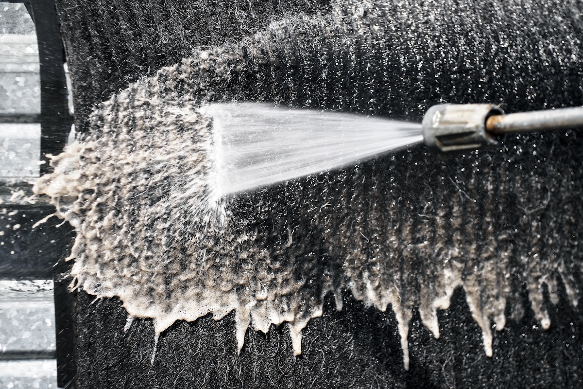 contactless washing of rugs and carpets with a water jet under pressure. professional clearing service for cleaning textile surfaces.